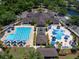 Aerial view of a community pool area featuring a lap pool, leisure pool, umbrellas, and plenty of lounge seating at 7934 Royal Birkdale Cir, Lakewood Ranch, FL 34202