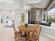 Cozy dining area with a view of the screened-in lanai and a stylish chandelier at 7934 Royal Birkdale Cir, Lakewood Ranch, FL 34202