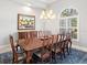 Dining room showcasing a large wooden table, seating for eight, and a decorative painting on the wall at 7934 Royal Birkdale Cir, Lakewood Ranch, FL 34202