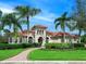 Mediterranean-style home with manicured landscaping, arched windows, and a red tile roof at 7934 Royal Birkdale Cir, Lakewood Ranch, FL 34202