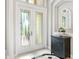Bright foyer with decorative glass front doors, accent mirror, black accent cabinet, and elegant tile flooring at 7934 Royal Birkdale Cir, Lakewood Ranch, FL 34202