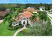 Beautiful home featuring well-manicured lawn and garden, mature palms and barrel tile roof in tropical setting at 7934 Royal Birkdale Cir, Lakewood Ranch, FL 34202