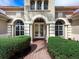 Home featuring barrel tile roof, arched windows and doorway, manicured landscaping, and brick walkway at 7934 Royal Birkdale Cir, Lakewood Ranch, FL 34202