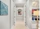 Bright hallway features tile floors, niche with floral view, and shelving with decorative objects at 7934 Royal Birkdale Cir, Lakewood Ranch, FL 34202