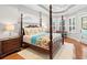 Spacious main bedroom features a four poster bed, wood floors, shuttered windows and tray ceiling at 7934 Royal Birkdale Cir, Lakewood Ranch, FL 34202