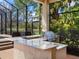 Outdoor kitchen with a stainless steel grill and a granite countertop for cooking and serving at 7934 Royal Birkdale Cir, Lakewood Ranch, FL 34202