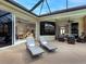 Covered patio area with comfortable lounge chairs and views of the interior living spaces at 7934 Royal Birkdale Cir, Lakewood Ranch, FL 34202