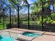 A pool and spa area is surrounded by a screened-in enclosure overlooking a lush landscape at 7934 Royal Birkdale Cir, Lakewood Ranch, FL 34202