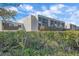 Exterior view of a white condo building with balconies, green bushes, and blue sky at 814 Bayport Way, Longboat Key, FL 34228