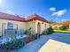 Charming house featuring a red tile roof, front patio, and lush landscaping at 916 W Faith Cir, Bradenton, FL 34212