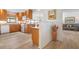 Kitchen featuring wood cabinets, laminate floors, and a seamless flow to the living and dining areas at 9527 Azure Cv, Bradenton, FL 34210