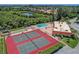 Aerial view of community tennis courts and pool surrounded by lush landscaping at 9527 Azure Cv, Bradenton, FL 34210