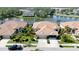 Aerial view of a beautiful home with well-manicured landscaping and a serene pond setting at 9539 Forest Hills Cir, Sarasota, FL 34238