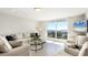 A bright living room with tile floors, stylish furniture, and a large sliding glass door leading to a balcony with water views at 101 S Gulfstream Ave # 14G, Sarasota, FL 34236