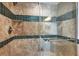 Close up of the renovated shower with a glass door, decorative tile, and built-in shelving at 101 S Gulfstream Ave # 14G, Sarasota, FL 34236