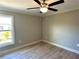 Bright bedroom featuring hardwood floors, ceiling fan, and a window bringing in natural light at 1056 Tampa Rd, Venice, FL 34293