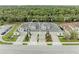Drone shot of multiple townhouses with well-kept lawns and driveways surrounded by mature trees and vegetation at 11607 Meadowgate Pl, Bradenton, FL 34211