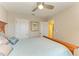 Bedroom with light blue bedding, ceiling fan, and a closet and ensuite entrance at 11607 Meadowgate Pl, Bradenton, FL 34211