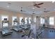 Well-equipped fitness center with modern machines, ceiling fans and ample natural light from large windows at 11607 Meadowgate Pl, Bradenton, FL 34211