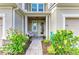 Inviting covered front porch with a decorative wreath, brick pavers and colorful, blooming landscaping at 11607 Meadowgate Pl, Bradenton, FL 34211
