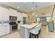 Bright kitchen featuring white cabinets, stainless steel appliances, an island with seating and open to the living room at 11607 Meadowgate Pl, Bradenton, FL 34211