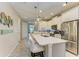Bright, white kitchen features an island with seating and stainless steel appliances at 11607 Meadowgate Pl, Bradenton, FL 34211