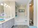 A soothing bathroom includes a soaking tub, grey vanity, and linen storage at 11607 Meadowgate Pl, Bradenton, FL 34211