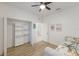 Bright bedroom with a ceiling fan, closet organizer, and light wood flooring at 12014 Forest Park Cir, Bradenton, FL 34211