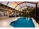 Gorgeous screened-in pool, patio, and outdoor living space with tropical landscaping and ambient lighting at 12014 Forest Park Cir, Bradenton, FL 34211