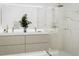 Modern bathroom featuring a double vanity, a large mirror, and a frameless glass shower with marble-look tile at 1305 4Th St # 202P, Sarasota, FL 34236