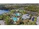 Aerial view of a community pool area featuring multiple pools, waterslides, and tropical landscaping for resort-style living at 13149 Steinhatchee Loop, Venice, FL 34293