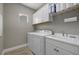A bright laundry room featuring a washer, dryer, sink, tile floor, and ample storage at 13149 Steinhatchee Loop, Venice, FL 34293