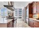 Modern kitchen with marble floors, stainless steel appliances, and wooden cabinets bathed in natural light from large windows at 1350 Main St # 1701, Sarasota, FL 34236