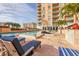 Community pool area with lounge chairs, palm trees, and a view of the high-rise condo building at 1350 Main St # 1701, Sarasota, FL 34236