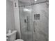 Modern bathroom with a glass-enclosed shower featuring marble tiling and a built-in niche at 1350 N Portofino Dr # 108, Sarasota, FL 34242