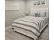 Comfortable bedroom featuring a cozy bed with striped bedding and plantation shutters at 1350 N Portofino Dr # 108, Sarasota, FL 34242