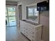 Bedroom featuring dresser with mirror, showing waterfront views through the sliding glass door at 1350 N Portofino Dr # 108, Sarasota, FL 34242