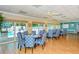 Bright common room with dining tables and a pool view through sliding glass doors at 1350 N Portofino Dr # 108, Sarasota, FL 34242
