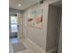 Entryway with beach themed art, light gray walls, white trim, light colored floors, and front door at 1350 N Portofino Dr # 108, Sarasota, FL 34242