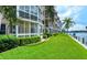 Waterfront condo with lush green lawn, landscaping and screened in lanai overlooking the water at 1350 N Portofino Dr # 108, Sarasota, FL 34242
