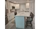 The bright, remodeled kitchen features white cabinets, stainless appliances, and a central island at 1350 N Portofino Dr # 108, Sarasota, FL 34242