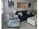 Cozy living room featuring a comfortable sofa, decorative artwork, and a coastal-themed armchair at 1350 N Portofino Dr # 108, Sarasota, FL 34242