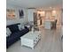 Open-concept living area with a blue sofa, stylish decor, and a view into the modern kitchen at 1350 N Portofino Dr # 108, Sarasota, FL 34242