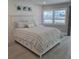 Serene bedroom with a white bed, shiplap wall, and views of the waterfront at 1350 N Portofino Dr # 108, Sarasota, FL 34242