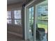 Relaxing patio view from sliding glass doors; showcases the waterfront with lush green landscaping and calming canal at 1350 N Portofino Dr # 108, Sarasota, FL 34242