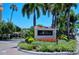 Entrance to Siesta Harbor complex, surrounded by vibrant landscaping, palm trees, and manicured grounds at 1350 N Portofino Dr # 108, Sarasota, FL 34242