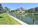 Waterfront condo complex featuring boat docks, lush landscaping, and a building at 1350 N Portofino Dr # 108, Sarasota, FL 34242