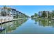 Beautiful waterfront view of complex with boat docks and buildings with tropical landscaping on a sunny day at 1350 N Portofino Dr # 108, Sarasota, FL 34242