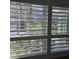 View through window shutters showing the waterfront and palm trees, bringing the outside in at 1350 N Portofino Dr # 108, Sarasota, FL 34242