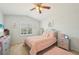 Well-lit bedroom featuring a charming pink-themed décor, window with shutters and ceiling fan at 1655 Pinyon Pine Dr, Sarasota, FL 34240